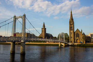Naklejka premium A wrought iron suspension bridge, which acts as a pedestrian crossing over the River Ness in Inverness, Scotland.