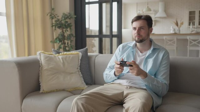 Excited Man Playing Video Game On Console Enjoying, Winning While Sitting Home