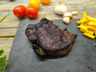 Delicious fried steak on a granite edged board, next to French fries