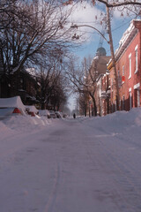 View on a snow-covered street with cars parked
