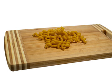 Pasta on wooden board with white transparent background, texture. Cooking, dry product