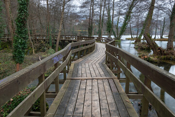 Fototapeta premium Winding wooden pedestrian bridge on Pliva lake near Jajce