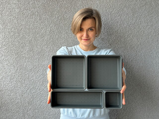 Woman holding a set of gray plastic organizers in front of her