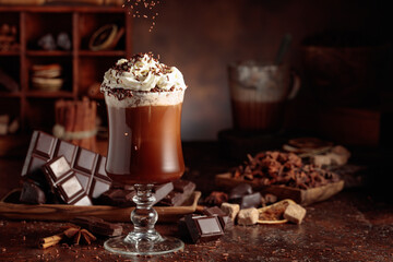 Hot chocolate topped with whipped cream and sprinkled with chocolate chips.