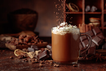 Chocolate drink topped with whipped cream and sprinkled with chocolate chips.