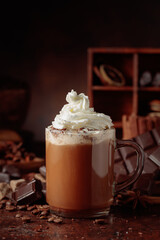 Hot chocolate with whipped cream in a glass mug.