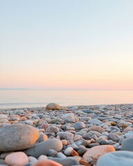 Obraz premium Glistening pebbles by the serene seashore at sunset coastal landscape tranquil environment