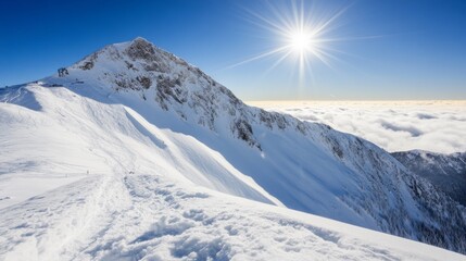 Fototapeta premium Snowy Mountain Peak Under Bright Sunlight Against Blue Sky