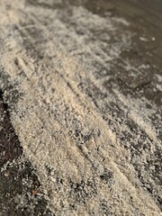 Closeup on rock salt on sidewalk applied to melt ice and snow
