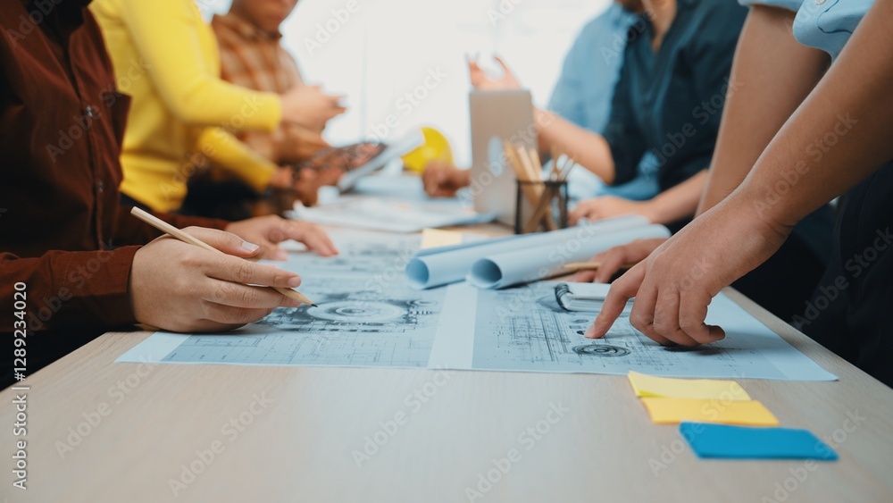 Poster a group of professionals engaged in a collaborative planning session, discussing charts and blueprin