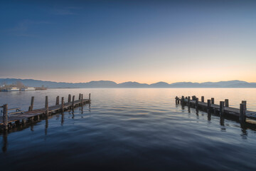 Fototapeta premium Two Wooden Piers at Sunrise in Lake Massaciuccoli. Torre del Lago, Tuscany, Italy