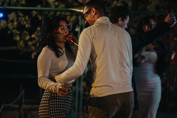 Friends gather to celebrate a vibrant outdoor birthday party at night, enjoying fun, conversation, and festive activities, creating a cheerful and memorable celebration filled with joy and laughter.