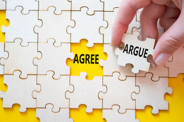 Fototapeta premium Agree or Argue symbol. Concept word Agree or Argue on wooden puzzle. Businessman hand. Beautiful yellow background. Business and Agree or Argue concept. Copy space