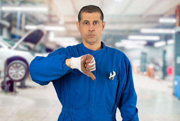 Mature caucasian man at repair shop wearing mechanic uniform with angry face, negative sign showing...
