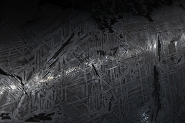 Polished dark meteorite surface with chaotic crysal pattern © evannovostro