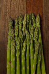Raw asparagus stems spread out, on a cutting board.