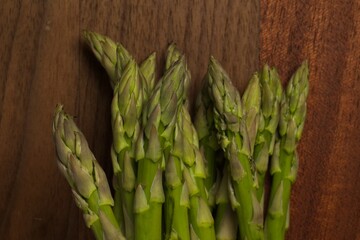 Tops of a raw asparagus bundle, on a cutting board.