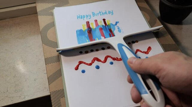 Creating a colorful birthday card with scrabble painting techniques in a bright workshop