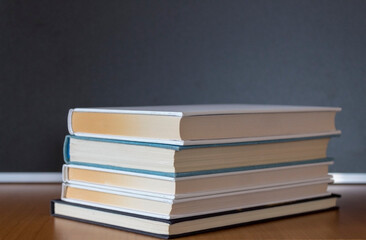 Pile of books on wooden table with dark background and copy space.