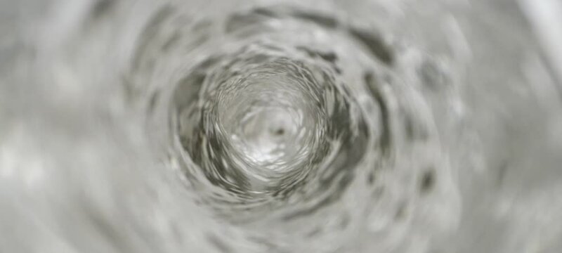 Water vortex swirling anticlockwise in slow-motion - Top view from the inside