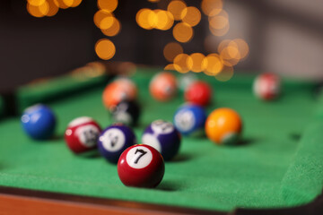 Many colorful billiard balls on green table indoors, closeup