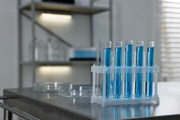 Test tubes with blue liquid on table in laboratory. Space for text