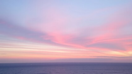 Soft pastel sunset over the calm ocean, with gentle hues of pink, purple, and blue blending in the sky. The tranquil scene captures the serene beauty of nature.