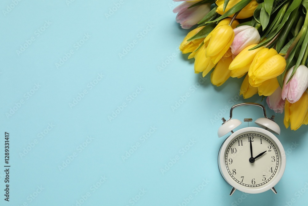 Poster spring time. alarm clock and beautiful tulips on light blue background, flat lay. space for text