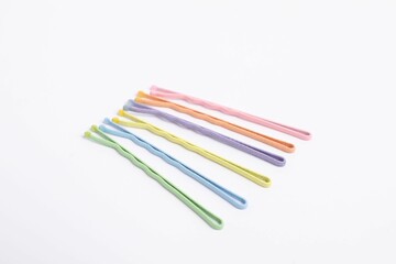 Many colorful hair pins on white background