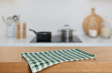 Green checkered tablecloth on wooden surface in kitchen