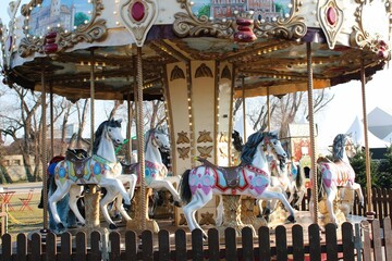 A beautifully decorated vintage carousel with ornate horses and glowing lights at an outdoor fair....