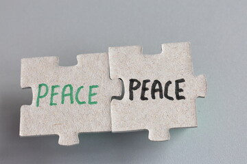 Peace or war concept. Puzzle pieces. Close up with gray background.