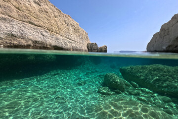 Fototapeta premium Underwater split photo of beautiful volcanic white rock caves with emerald clear sea