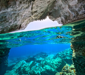 Obraz premium Underwater split photo of small cove and port of Kara famous for colourful boat houses called Sirmata, Kimolos island, Cyclades, Greece
