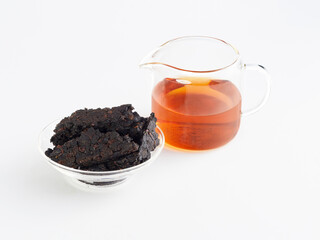 dried Chinese tea leaves and brewed drink in a transparent teapot on a white background