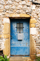 Old blue door tucked into a stone house