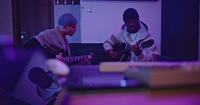 Musicians collaborating and playing guitars in a music studio, composing a new song.