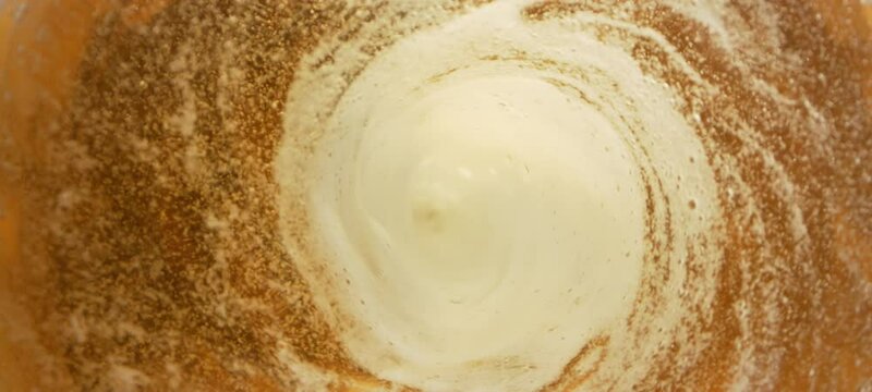 Super slow-motion of splashing whiskey wave creating tunnel shape. Filmed on high speed cinema camera, 1000 fps