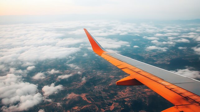 Airplane wing flying above clouds and ground views