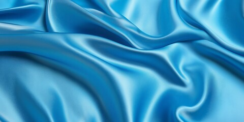 Obraz premium Vivid blue satin texture with dynamic folds and bright highlights creates a striking abstract background that enhances contemporary design elements in any setting or project