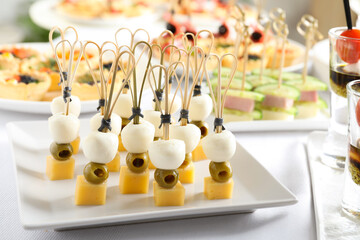 Many different tasty canapes on white table, closeup