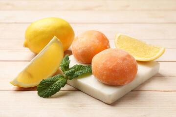Delicious mochi, lemons and mint on wooden table, closeup