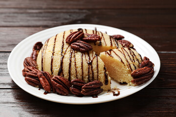 Delicious sweet semolina halva with pecans on wooden table, closeup