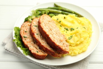Delicious baked turkey meatloaf with mashed potato served on white wooden table, closeup