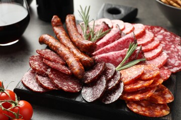 Different smoked sausages slices served on grey table, closeup