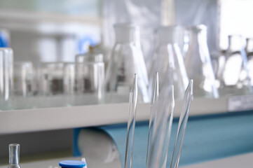 Laboratory glassware and pipettes arranged on a workbench, showcasing scientific tools for experiments in a clean environment