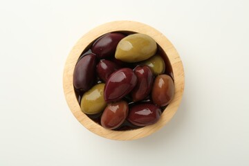 Tasty marinated olives in bowl on white table, top view