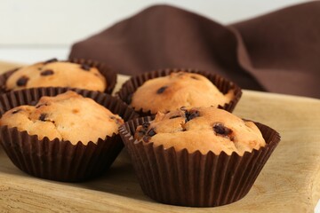 Delicious muffin with chocolate chips on table, closeup