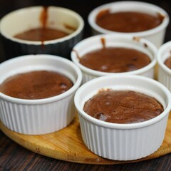Closeup shot of servings of chocolate creme brulee on a wooden tray
