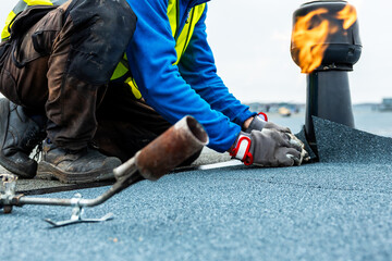Worker Applies Roofing Material with Gas Torch on Flat Roof
